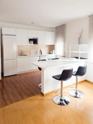 a kitchen with a white counter and two bar stools at Lux Studio Apartment Vidanovic in Pirot
