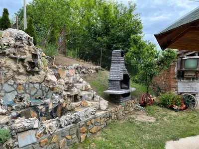 a stone wall with a stone oven in a yard at Kuca Mihajlovic in Svrljig