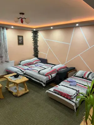 a room with two beds and a table in it at Kuca Mihajlovic in Svrljig