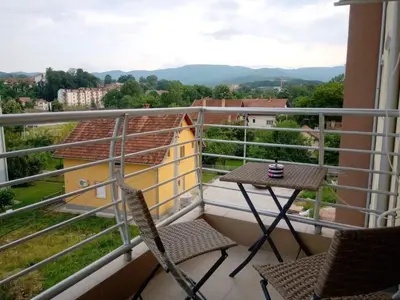 a balcony with chairs and a table and a view at Studio Dorna in Vrnjačka Banja