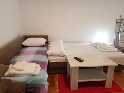 a room with two twin beds and a table at Studio Dorna in Vrnjačka Banja