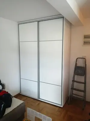 a sliding glass door in a room with a ladder at Studio Dorna in Vrnjačka Banja