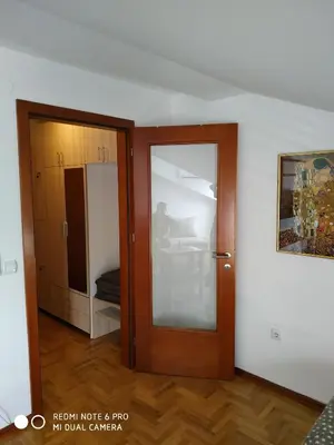 a room with a wooden door and a bedroom at Apartman ZENIT in Vrnjačka Banja