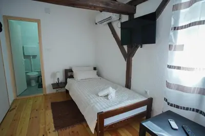 a small bedroom with a bed and a television at Epicenter in Niš