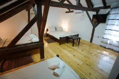 an attic room with two beds and a table at Epicenter in Niš