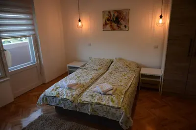 a bedroom with a bed with two tables and a window at VIV apartment 1 in Niš