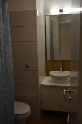 a bathroom with a sink and a toilet and a mirror at VIV apartment 1 in Niš