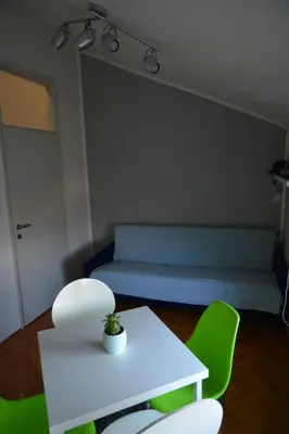 a living room with a couch and a table and chairs at VIV apartment 2 in Niš