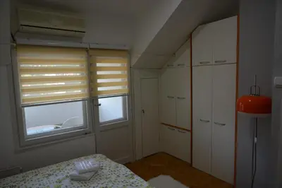 a bedroom with a bed and a window with blinds at VIV apartment 2 in Niš