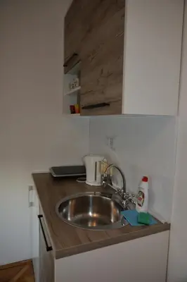 a sink in a kitchen with a wooden counter top at VIV apartment 2 in Niš