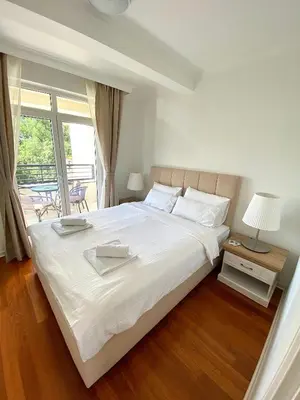 a bedroom with a large white bed and a window at Lux Apartman 'Opereta' A-19 in Vrnjačka Banja