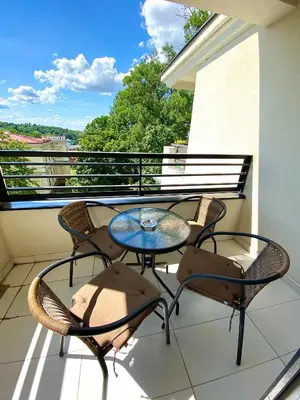a patio table and chairs on a balcony with a view at Lux Apartman 'Opereta' A-19 in Vrnjačka Banja