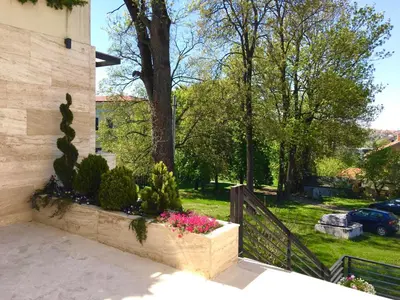 a stone retaining wall with flowers in a garden at Lux Apartman 'Opereta' A-19 in Vrnjačka Banja