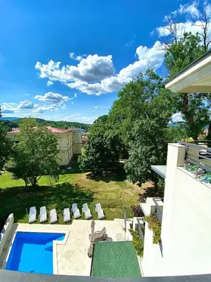 a view of a backyard with a pool and chairs at Lux Apartman 'Opereta' A-19 in Vrnjačka Banja