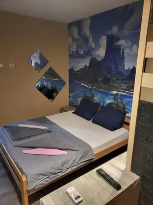 a bedroom with a bed with a painting on the wall at Apartments Day Off in Aleksinac