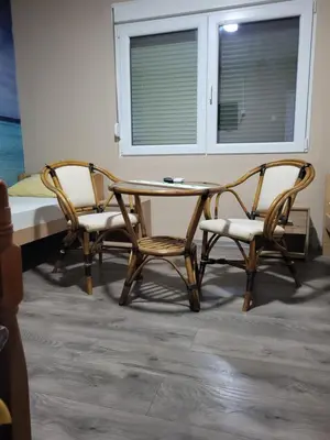 two chairs and a table in a room with a bed at Apartments Day Off in Aleksinac
