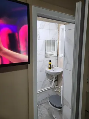 a bathroom with a sink and a toilet and a tv at Apartments Day Off in Aleksinac