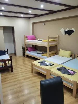 a room with three bunk beds and a chair at Apartments Day Off in Aleksinac