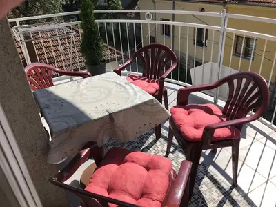 a table and four chairs on a balcony at Apartman “MEGI” in Soko Banja