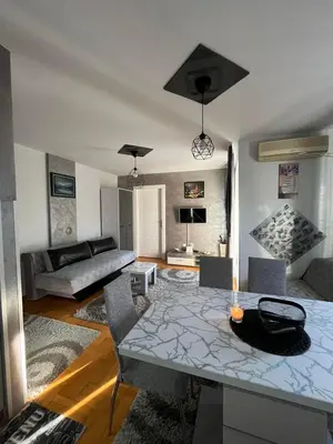 a living room with a table and a couch at Apartman “MEGI” in Soko Banja