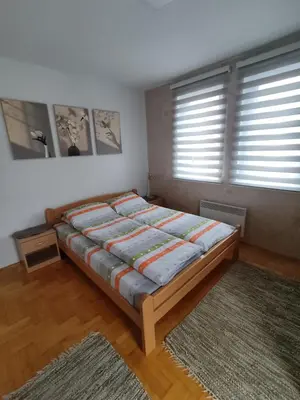 a bedroom with a bed and a large window at Apartman “MEGI” in Soko Banja