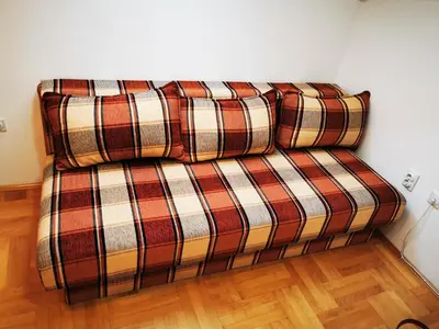a couch with two pillows on it in a room at Sokobanja central park APT with mountain view balcony in Soko Banja