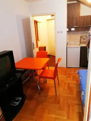 a living room with a table and a kitchen at Sokobanja central park APT with mountain view balcony in Soko Banja