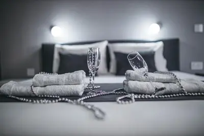 a table with towels and wine glasses on a bed at King Exclusive Suites in Niš