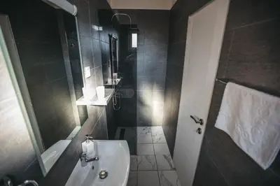 a bathroom with a shower and a sink and a toilet at King Exclusive Suites in Niš