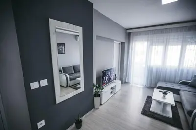 a living room with a couch and a mirror at King Exclusive Suites in Niš