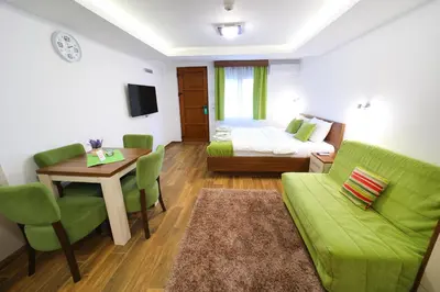 a living room with a green couch and a table at Vila Almax in Soko Banja