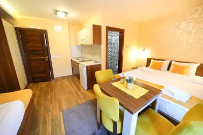 a hotel room with a bed and a table and chairs at Vila Almax in Soko Banja