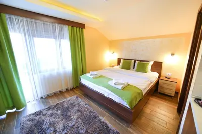 a bedroom with a bed and a large window at Vila Almax in Soko Banja