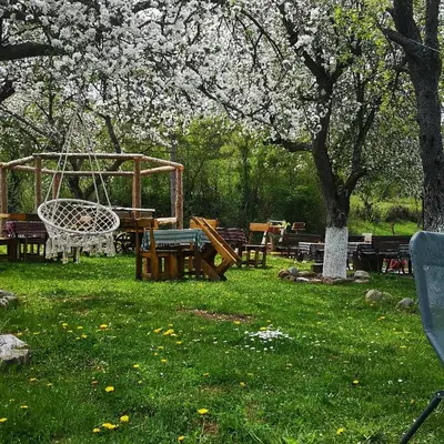 a park with benches and a swing in the grass at Etno Konak Angela in Kalna