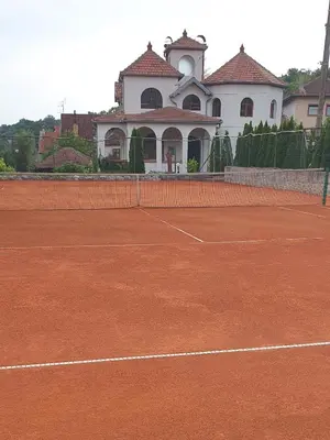 a tennis court in front of a building at Knez Apartmani in Senje