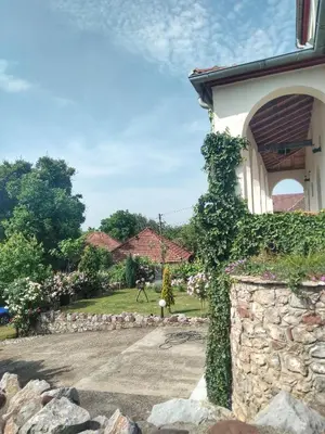 a house with a stone wall and a yard at Knez Apartmani in Senje
