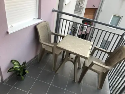 a table and two chairs on a balcony at La Apartamento in Jagodina