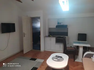 a small living room with a table and a kitchen at Apartmani Marić In in Vrnjačka Banja