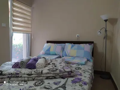a bed with blankets and pillows next to a window at Apartmani Marić In in Vrnjačka Banja