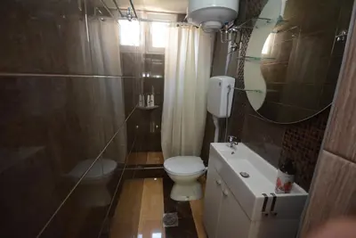 a bathroom with a toilet and a sink and a mirror at Apartmani Marić In in Vrnjačka Banja