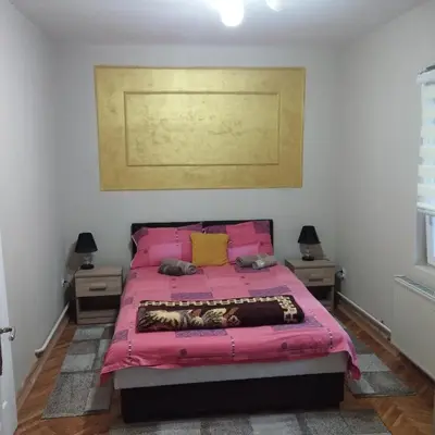 a pink bed in a bedroom with two night stands at Apartmani Marić In in Vrnjačka Banja