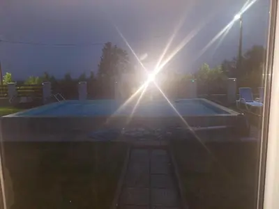 a sun shining over a swimming pool in a yard at Vila Boba Bor in Zlot