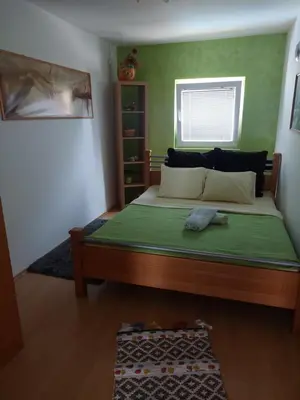 a bedroom with a large bed with a green wall at Vila Boba Bor in Zlot