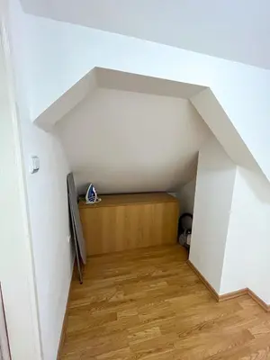 an attic room with a bed in the middle at Apartmani Djokić sa bazenom in Soko Banja