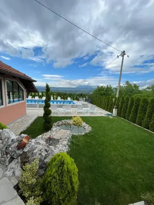 a backyard with a lawn and a pool at Apartmani Djokić sa bazenom in Soko Banja