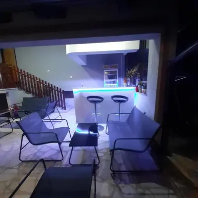 a group of chairs and a bar in a room at Apartmani Djokić sa bazenom in Soko Banja