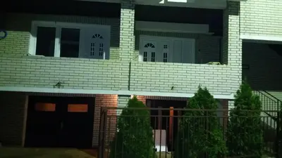 a house with black doors and a fence at Apartman Lela in Vranje