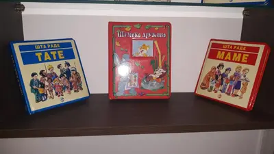three books are sitting on a shelf at Apartman Lela in Vranje