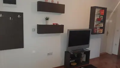 a living room with a flat screen tv on a wall at Apartman Lela in Vranje