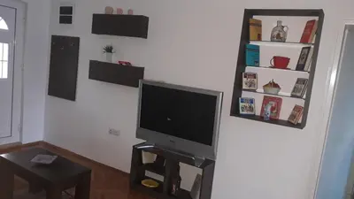 a living room with a flat screen tv on a wall at Apartman Lela in Vranje